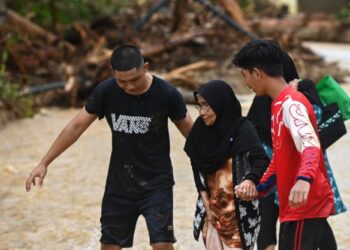 PENDUDUK meredah sungai pulang ke rumah selepas banjir mulai surut dalam tinjauan Utusan Malaysia di Kampung Betong, Hulu Terengganu, hari ini. - FOTO/PUQTRA HAIRRY ROSLI