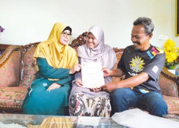 SAFWA Zamri (tengah) menunjukkan sijil pengiktirafan Top ACCA FIA Prize kepada ibu dan bapanya, Zamri Mohd. Amin serta Rashidah Ab. Rahman di Kampung Pengkalan Kubur, Tembila, Besut, Terengganu, semalam.