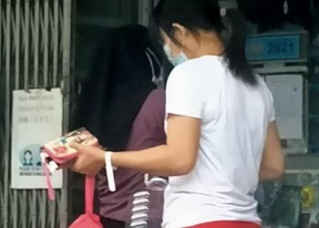 GAMBAR tular yang dikongsi pengguna dalam media sosial memaparkan wanita memakai gelang putih berada di sebuah kedai runcit di Taman Kota Jaya, Kota Tinggi, Johor.