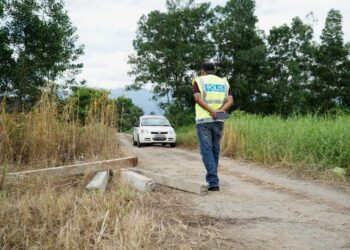 SARJAN Helmi Mat Rejab meninjau laluan alternatif yang dibina penduduk menghubungkan jalan besar ke Taman Simpang Bakti dan Kota Permai sejauh 500 meter di Simpang di Taiping hari ini. - UTUSAN/ZULFACHRI ZULKIFLI