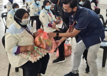 DUA penuntut UiTM cawangan Pulau Pinang menyerahkan sumbangan berupa barangan keperluan harian kepada seorang pekerja kontrak pembersihan universiti itu dalam program bantuan menjelang Aidilfitri.