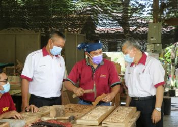 MOHD. Kheiruddin Mohd. Rani (dua dari kiri) melihat kemahiran mengukir kayu ditunjukkan A. Muhaimin Hasbollah di Pusat Inakraf Wood Carving Kampung Bangau Tanjung, Temerloh, Pahang, semalam.