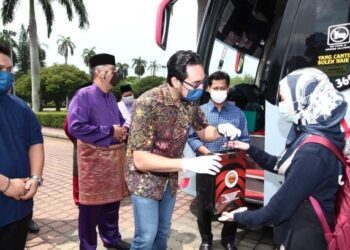 Wan Ahmad Fayhsal Wan Ahmad Kamal menyampaikan pelitup muka, fon telinga dan pensanitasi tangan kepada pelajar Universiti Putra Malaysia (UPM) yang pulang ke kampung halaman bagi menyambut Hari Raya Aidilfitri di Serdang, Selangor, kelmarin.