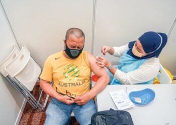 Seorang lelaki menerima vaksin penggalak di Pusat Dagangan Dunia (WTC), Kuala Lumpur, semalam. – MINGGUAN/SHIDDIEQIIN ZON