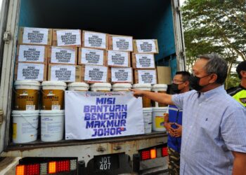 HASNI Mohammad (kanan) melihat barangan yang akan dihantar ke Selangor sempena Majlis Pelepasan Misi Bantuan Bencana Makmur Johor di Pejabat UMNO Johor. - UTUSAN/RAJA JAAFAR ALI