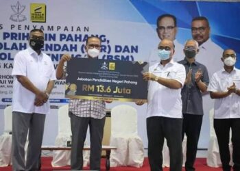 WAN ROSDY Wan Ismail (dua dari kiri) memegang replika cek RM13.6 juta inisiatif untuk Biasiswa Sekolah Rendah (BSR) dan Biasiswa Sekolah Menengah (BSM) Yayasan Pahang tahun ini di Sungai Koyan di Lipis, Pahang. - FOTO/HARIS FADILAH AHMAD