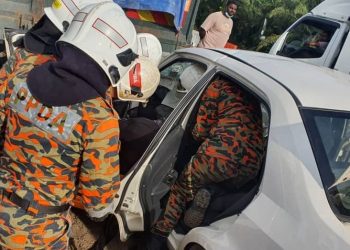 ANGGOTA bomba mengeluarkan mangsa yang tersepit dalam kereta yang terlibat kemalangan di Jalan Changkat Jong di Teluk Intan, Perak, hari ini. - IHSAN JBPM