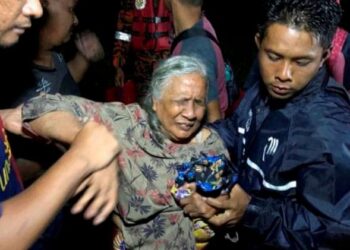 HALIJAH Taib diselamatkan anggota bomba dalam kejadian banjir kilat di Kampung Kotan, Mukim Jabi di sini semalam.