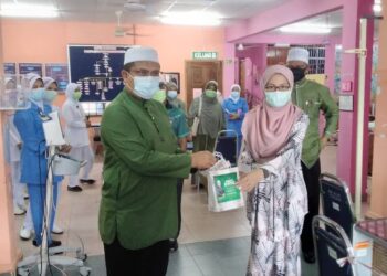 MOHD. Akmal Kamaruddin (kiri) menyampaikan cenderahati kepada kakitangan Klinik Kesihatan Selama semasa melawat klinik itu di Selama, Perak, hari ini. - UTUSAN/WAT KAMAL ABAS