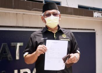 ABDUL Aziz Bari menunjukkan laporan polis yang dibuatnya mengenai satu poster yang mengaitkan DAP punca kalimah Allah digunakan oleh bukan Islam di IPD Ipoh hari ini. - UTUSAN/ZULFACHRI ZULKIFLI