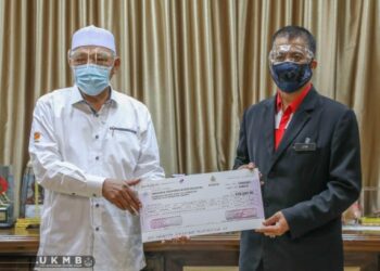 AHMAD (kiri) menyerahkan replika sumbangan RM500,000 kepada HRPZ II yang diwakili Dr. Zaini di pejabatnya di Kota  Bharu hari ini. - Ihsan Pejabat Menteri Besar