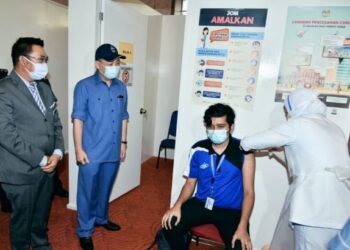 Hajiji Noor (dua kiri) bersama Setiausaha Kerajaan Negeri Sabah, Datuk Seri Safar Untong (kiri) menyaksikan proses vaksinasi di PPV Wisma Wanita, Kota Kinabalu hari ini