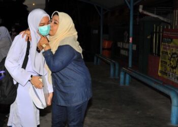 SEORANG ibu, Sharifah Roziah Syed Abdul Ghafar (kanan) mencium anaknya, Sharifah Marzuin Shaziera Syed Mahdhar yang akan menduduki peperiksaan SPM sebelum melangkah masuk ke SMK Perempuan Sultan Ibrahim di Johor Bahru, Johor. -UTUSAN/ RAJA JAAFAR ALI