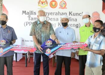 MAHDZIR Khalid menyampaikan replika kunci rumah kepada  penduduk perumahan Taman Desa Pudina, Projek Pemajuan Kawasan (PPK) Kubang Kenyeng, Padang Terap hari ini.