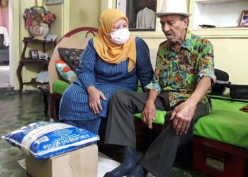 ZAITON Ismail (kiri) ketika menyantuni seniman legenda Mat Sentol atau nama sebenarnya, Abdul Rashid Yahya dalam kunjungannya ke kediaman beliau di Larkin Jaya, Johor Bahru di Johor. -UTUSAN/KHAIRUL MOHD ALI