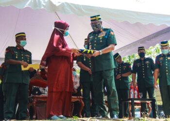 Panglima Tentera Darat, Jeneral Tan Sri Zamrose Mohd. Zain menyerahkan Jalur Gemilang kepada Lailawati selepas majlis pengebumian jenazah Prebet Ujang Mormin di Pusara Rejimen Askar Melayu Diraja (RAMD) di Port Dickson hari ini.-UTUSAN/MUHAMMAD IZZAT TERMIZIE.