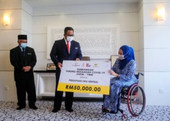 Ahmad Marzuk Shaary (tengah) menyampaikan sumbangan RM50,000 daripada Tabung Musaadah COVID-19 Jakim-Yayasan Wakaf Malaysia (YWM) kepada Ras Adiba Mohd Radzi di Kompleks Islam Putrajaya di sini, hari ini.