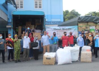 Petugas bersama pakaian dan barangan keperluan yang akan dihantar ke kawasan perkampungan Orang Asli di Perak dan Kelantan dalam Program Amal Jarian Bundle di Benut, Pontian, Johor. -UTUSAN/MUHAMMAD ZIKRI