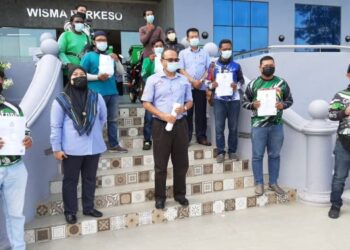 ABD. RAZAK Omar (tengah) bersama sebahagian daripada penghantar makanan yang telah mendaftar skim SPS di pejabat Perkeso, Ayer Keroh, semalam. - UTUSAN/AMRAN MULUP