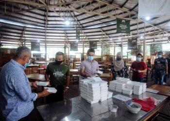 NORDIN Mat  (kiri) melayani pelanggan yang datang untuk membeli Nasi Bajet berharga RM2 di MAEPS  Serdang semalam