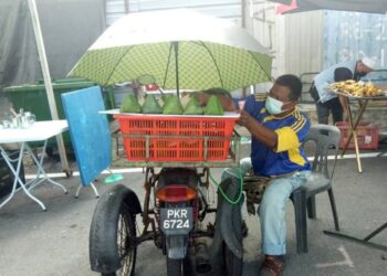 MOHD. Asri Mohd Ismail mencari rezeki dengan menjual nasi lemak menggunakan motosikal roda tiga di Bazar Ramadan Tanjong Tokong, Pulau Pinang. – Mingguan/SAFINA RAMLI