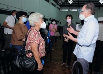 ANWAR Ibrahim beramah mesra dengan penduduk yang hadir untuk menerima vaksin di PPV di Dewan Kompleks Belia dan Sukan Telok Kemang, Port Dickson, hari ini-FOTO/MOHD SHAHJEHAN MAAMIN.