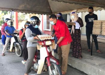 MOHD. Syahbuddin Hashim menyerahkan bantuan makanan secara pandu lalu kepada penerima di perkarangan Pusat Khidmat ADUN Galas di Bandar Utama, Gua Musang, Kelantan,kelmarin. – UTUSAN/AIMUNI TUAN LAH