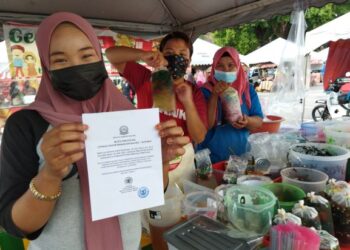 NURUL Syadira Abdullah Mohd. Shukri menunjukkan notis penutupan operasi bazar Ramadan yang dikeluarkan oleh Majlis Daerah  Baling (MDB) di tapak Bazar Ramadan di pekan Baling, semalam. 
– MINGGUAN/NORLIA RAMLI