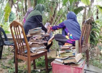 PELAJAR membasuh buku guru mereka yang diselaputi lumpur dalam banjir di Larut, semalam. – UTUSAN /WAT KAMAL ABAS