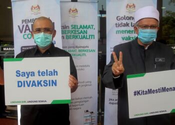 Zulkifli Mohamad Al-Bakri (kanan) bersama Ronald Kiandee menunjukkan Kad Vaksinasi Covid-19 selepas menerima suntikan vaksin Covid-19 di Pejabat Kesihatan Daerah Putrajaya Presint 11 hari ini.