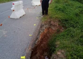 JHANGIR Khan Kathem Khan menunjukkan kesan tanah mendap di jalan antara pekan Kupang ke Kampung Tebing Tinggi, Baling hari ini.