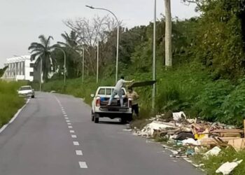 GAMBAR dua lelaki membuang sampah di bahu jalan di Lorong Tembikai, Teluk Intan yang menjadi punca pembuangan sampah haram. - UTUSAN/GAMBAR MEDIA SOSIAL