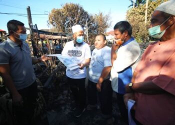 EBIT Liew (dua, kiri) berbincang dengan Mohd  Yazid (tengah) bersama dua lagi adik beradiknya mengenai rancangan membina semula rumah mereka yang musnah terbakar di Kampung Pangkalan Nangka, Kota Bharu petang ini.
Foto ZULHANIFA SIDEK