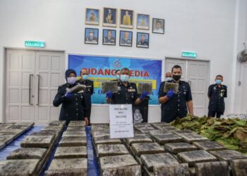 ZAINUDIN Ahmad (tengah) dan Surina (kiri) menunjukkan ganja yang dirampas seberat 250 kilogram dalam sidang akhbar di IPK Perlis di Kangar, Perlis hari ini.- UTUSAN/SHAHIR NOORDIN