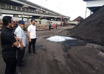 AZMIZAM (kanan) bersama Ahmad Fadzli (tengah) melihat timbunan arang yang disimpan di gudang tersebut di Jalan Kem, Pelabuhan Klang, Selangor hari ini-UTUSAN/MOHAMAD NAUFAL MOHAMAD IDRIS