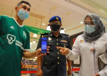 AIN Arjuna Aziz Zaman (kanan) melihat seorang pelanggan yang mendaftar masuk ke sebuah pasar raya di Seremban 2, Seremban dalam Operasi Penguatkuasaaan Had Masa 2 Jam di sebuah pasar raya hari ini-FOTO/MUHAMMAD IZZAT TERMIZIE.