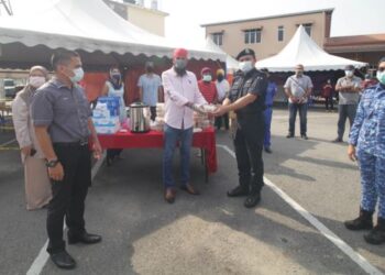 JASVIR Singh Ram Singh menyampaikan simbolik sumbangan makanan panas kepada Muhammad Hafiz Abdullah (dua dari kanan) sambil disaksikan Mohd. Zulkifli Hashim (kiri) di Pondok Kawalan Kampung Kemansur di Bentong, Pahang semalam.