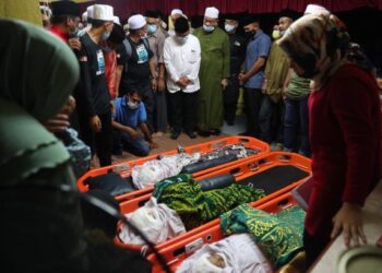 MUHAMMAD Alhafiz Mohamad (duduk, berbaju biru) menatap ketiga-tiga jenazah anaknya yang dibawa ke rumah keluarga mereka di Taman Seri Jati, Batu Berendam, Melaka. UTUSAN/ RASUL AZLI SAMAD