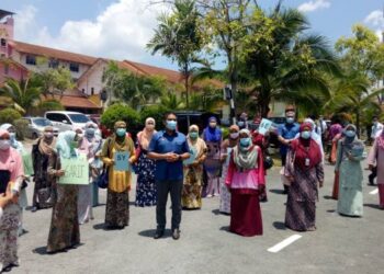 MOHD. RADZI Jidin bergambar dengan sebahagian guru terlibat proses penyuraian murid sesi pagi di Sekolah Kebangsaan Cyberjaya 1, Sepang, Selangor hari ini. - UTUSAN/AMREE AHMAD