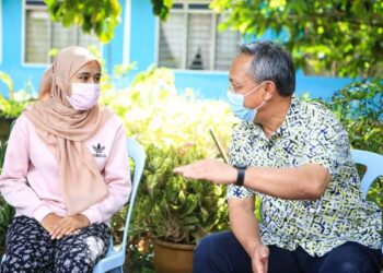 HASNI Mohammad (kanan) berbual bersama Nor Farziana Najwa Fauzi ketika berkunjung ke rumah calon SPM itu di Kampung Parit Wahab, Benut di Pontian, Johor.