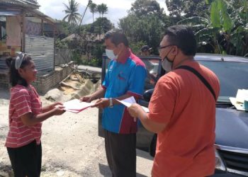 MOHD. SHAFII A. Bakar (tengah) menghantar modul pembelajaran ke setiap rumah murid Orang Asli di Kampung Sungai Pergam di Kemaman, hari ini. UTUSAN/NIK NUR IZZATUL HAZWANI NIK ADNAN