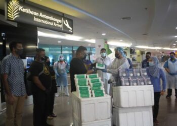 TARIQ Madarsha Hajashareef (tengah) menyerahkan sumbangan makanan kepada barisan frontliner yang bertugas di LTPP, Bayan Lepas, Pulau Pinang hari ini. Foto/ MUHAMMAD FIRDAUS AMRAN