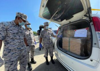 MUHD.  Nur Syam Asmawie Yaacob (kanan) menunjukkan MPV sarat dengan muatan rokok di pejabat Maritim Malaysia Kelantan di Tok Bali, Pasir Puteh hari ini.
Foto TOREK SULONG