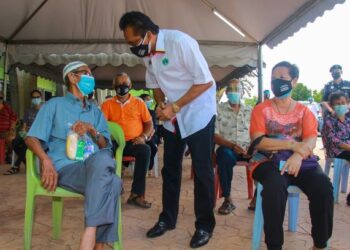 MOHD. Salim Mohd. Sharif beramah mesra penerima vaksin di PPV Dewan Pejabat Daerah Jempol, Bandar Seri Jempol, Jempol hari ini.-UTUSAN/MUHAMMAD IZZAT TERMIZIE.