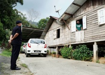 TAPAH, 21 JANUARI 2021 -Ketua Polis Daerah Tapah, Superintendan Wan Azharuddin Wan Ismail (kiri) bertanya khabar kepada Abas Bah Kecil (kanan) penduduk Kampung Orang Asli Batu 6 Jalan Pahang,Tapah yang dikenakan PKPD di kawasan tersebut hari ini. Foto - ZULFACHRI ZULKIFLI