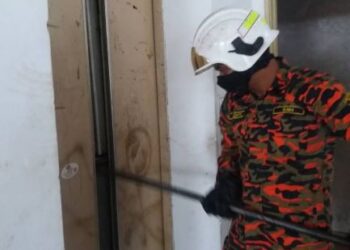 Anggota bomba mengumpil pintu lif bagi membawa keluar mangsa yang terperangkap di dalam lif .