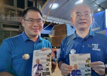 WEE Ka Siong (kanan) dan Pengerusi Jawatankuasa Kesihatan dan Perpaduan Johor, Ling Tian Soon menunjukkan Lima Aku Janji yang dilancarkan di Taman Kota, Yong Peng.