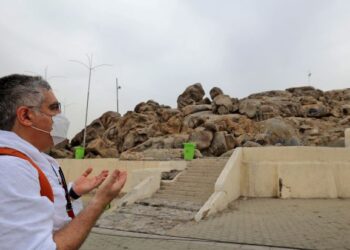 SEORANG jemaah haji menadah tangan berdoa semasa berwukuf di Arafah, Mekah berdekatan bukit dikenali sebagai Jabal Rahmah, semalam. Tahun ini kerajaan Arab Saudi hanya membenarkan 60,000 orang terdiri daripada rakyatnya dan warga asing yang tinggal di negara itu sahaja menunaikan rukun Islam kelima itu berikutan pandemik Covid-19.– AFP