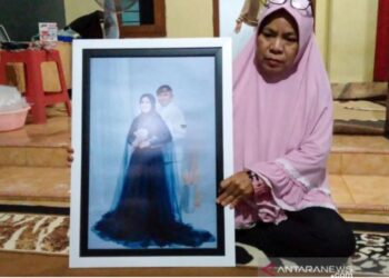 YAYAK Dwi Ernawati menunjukkan gambar perkahwinan anaknya dengan Pandu Yudha Kusuma. - ANTARA FOTO