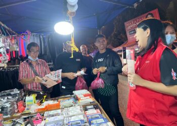 YEO Bee Yin mengedarkan risalah kepada peniaga dan orang awam ketika sesi walkabout di pasar malam Taman Pinggiran Putra, Puchong, Selangor.-UTUSAN/KAMARIAH KHALIDI